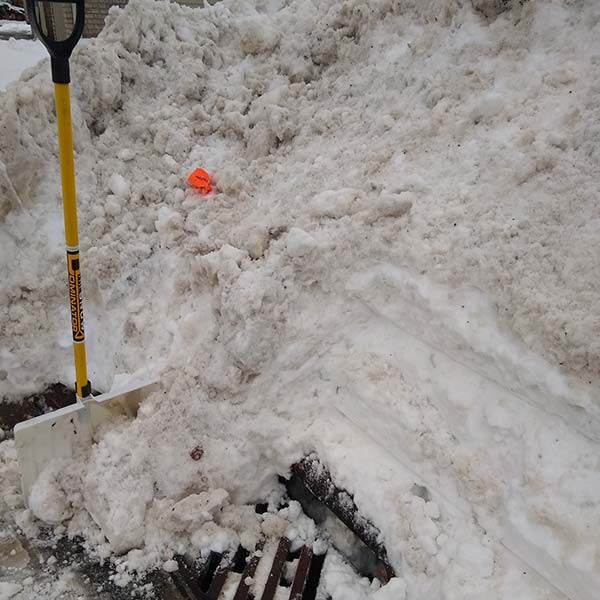 Snow being cleared from a storm drain