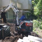 A rain garden being installed near an apartment