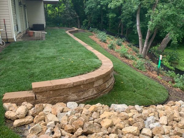 The completed project of a retaining wall and rain garden install
